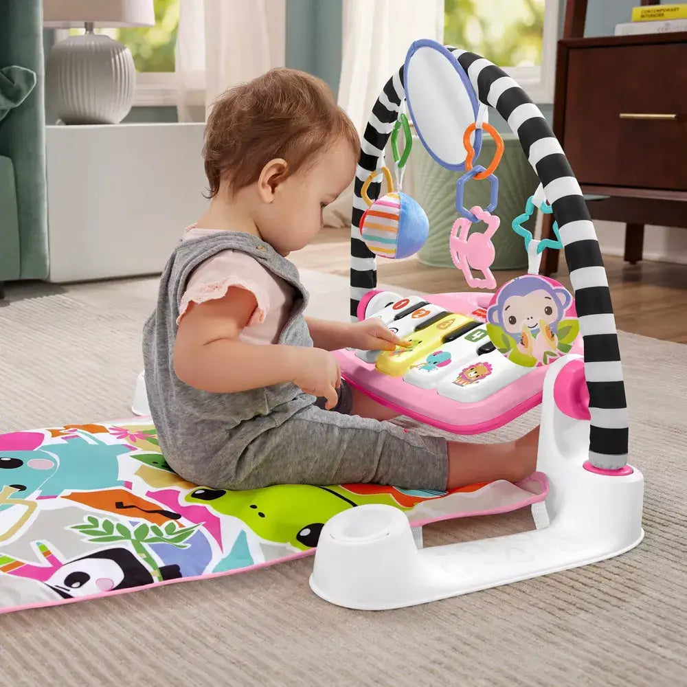 Girl playing with the Fisher-Price Glow and Grow Kick & Play Piano Gym (Pink)