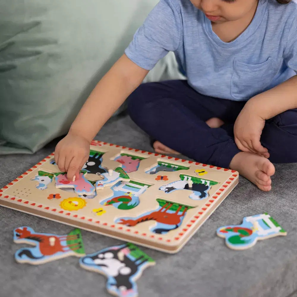 Another image of the girl playing Melissa and Doug Farm Animals 8 Piece Sound Puzzle