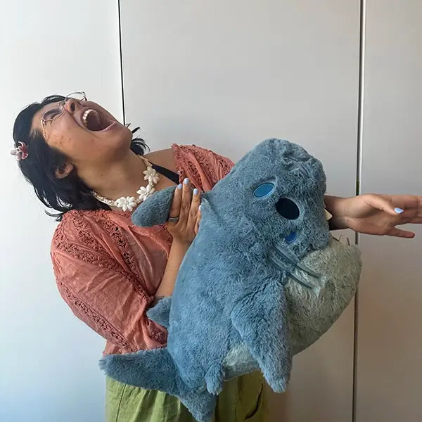 Person laughing and holding the Squishable Megalodon Plush